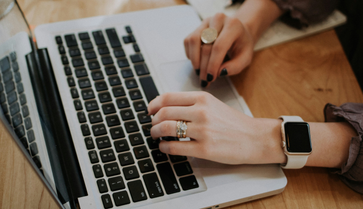 Close up image of hands typing at a laptop